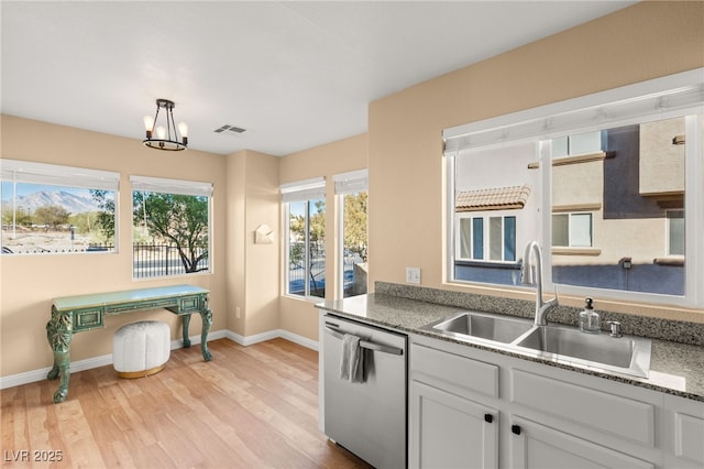 kitchen featuring dishwasher, decorative light fixtures, white cabinetry, light hardwood / wood-style floors, and sink