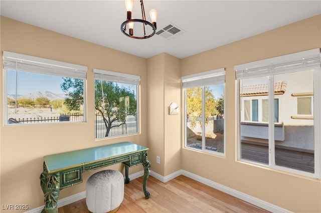 office space with a chandelier, a mountain view, and hardwood / wood-style flooring