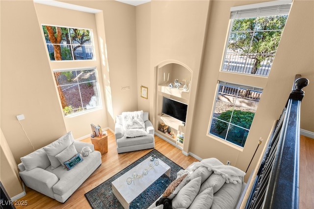 living room with plenty of natural light, built in features, and hardwood / wood-style floors