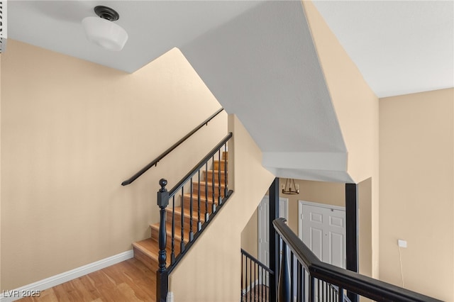 staircase featuring hardwood / wood-style floors and lofted ceiling