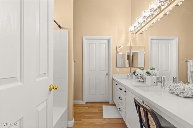 bathroom with wood-type flooring, washtub / shower combination, and vanity