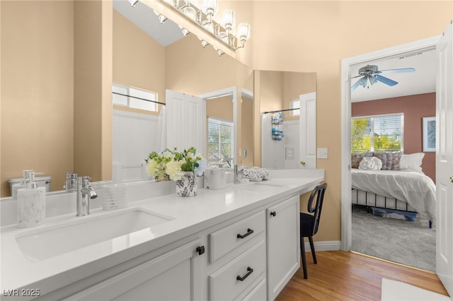 bathroom with hardwood / wood-style flooring, vanity, ceiling fan, and a healthy amount of sunlight