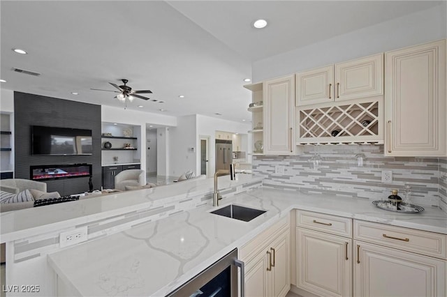 kitchen featuring kitchen peninsula, sink, and light stone counters