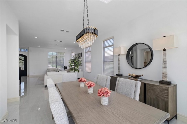 dining area with a healthy amount of sunlight and a chandelier