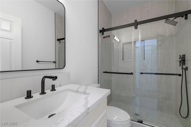 bathroom with toilet, vanity, and walk in shower