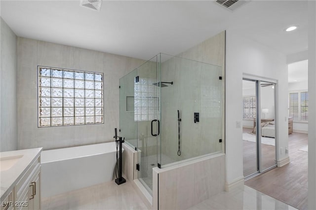 bathroom with tile patterned floors, vanity, and shower with separate bathtub