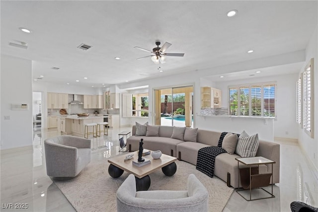 living room featuring ceiling fan and plenty of natural light