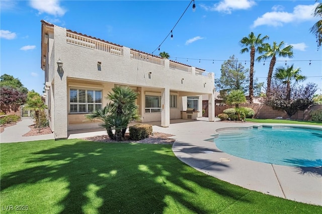 rear view of property featuring a patio area and a yard