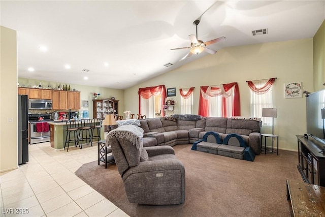 living room with lofted ceiling, light tile patterned floors, and ceiling fan