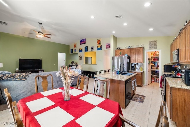 dining room with ceiling fan, sink, vaulted ceiling, and light tile patterned floors