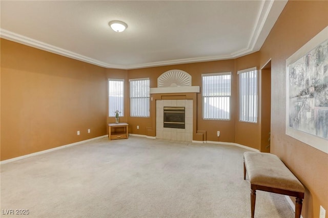 unfurnished living room featuring carpet floors, a wealth of natural light, a tile fireplace, and ornamental molding