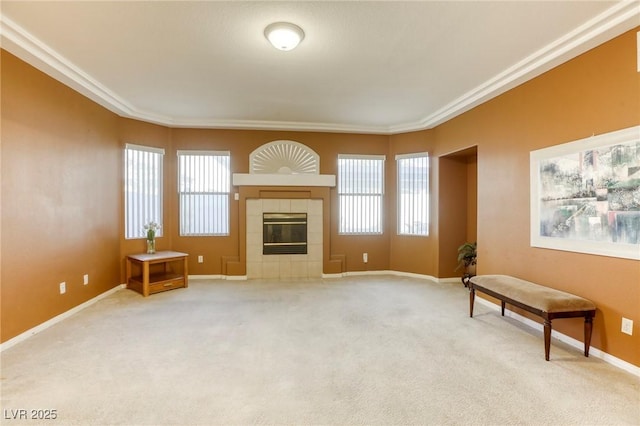 living room featuring light carpet, a healthy amount of sunlight, a tiled fireplace, and ornamental molding