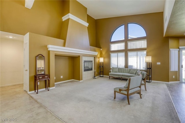 living room with carpet floors, a tile fireplace, and a towering ceiling