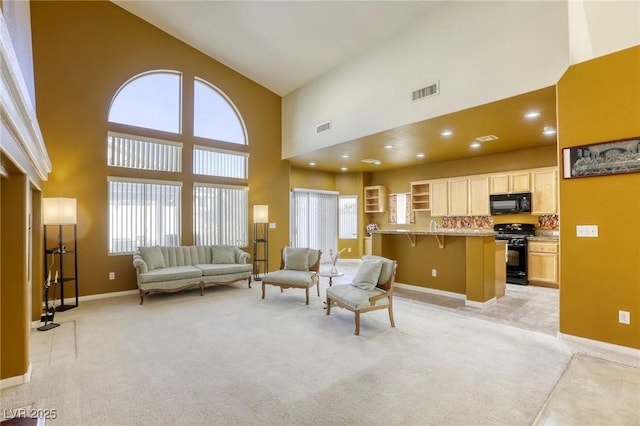 carpeted living room featuring a high ceiling