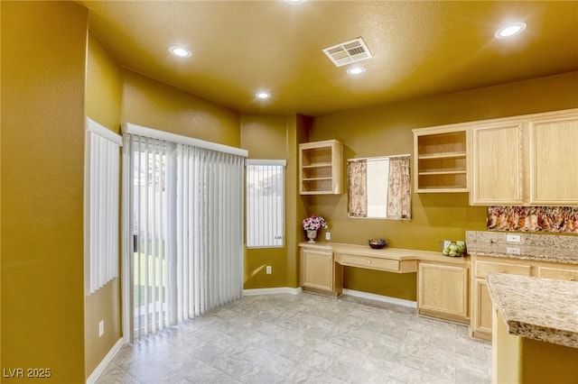 kitchen with built in desk and light brown cabinetry