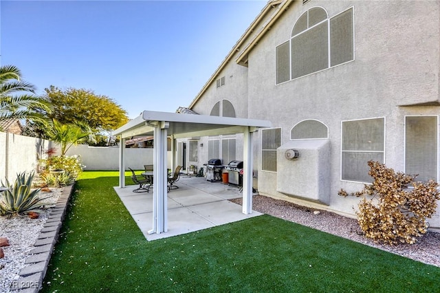 rear view of property featuring a lawn and a patio