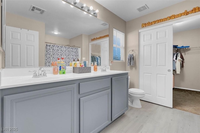 bathroom featuring hardwood / wood-style floors, toilet, vanity, and a shower with curtain