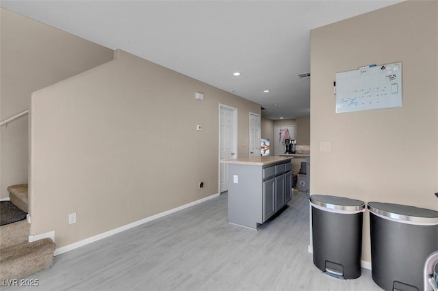 kitchen with light hardwood / wood-style flooring, gray cabinets, and a kitchen island