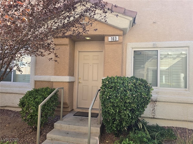 entrance to property featuring stucco siding