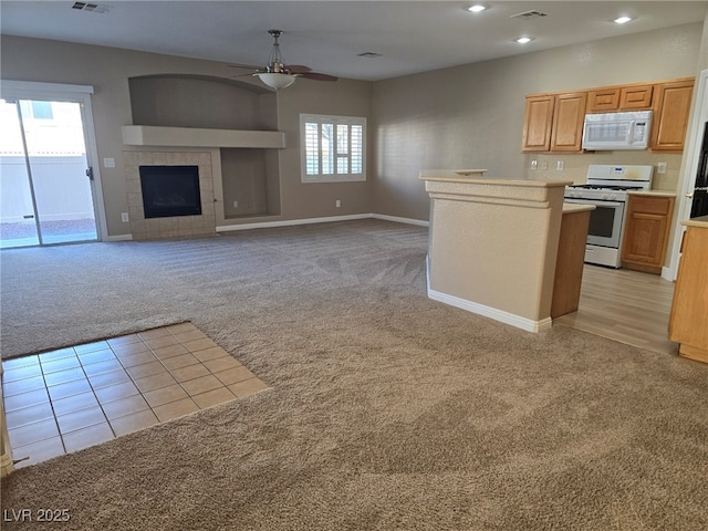 kitchen featuring a fireplace, light countertops, open floor plan, light carpet, and white appliances