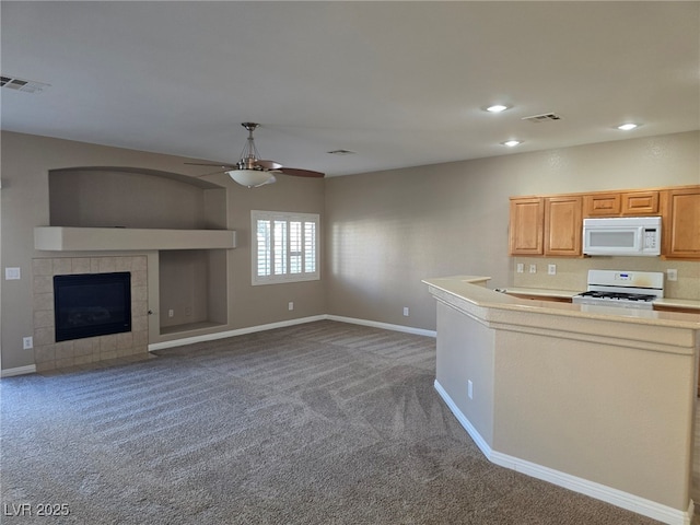 kitchen featuring carpet, light countertops, visible vents, open floor plan, and white appliances