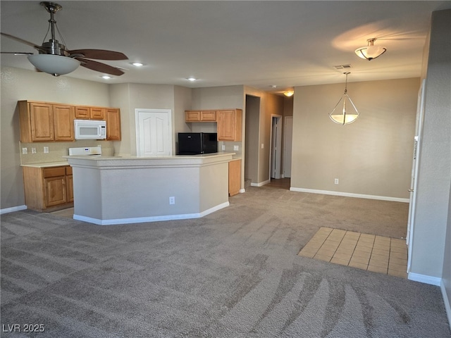 kitchen with light countertops, hanging light fixtures, white microwave, freestanding refrigerator, and light carpet