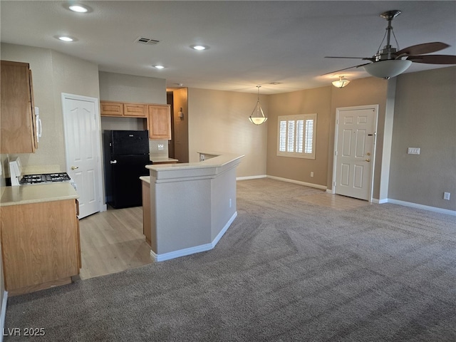 kitchen featuring visible vents, light colored carpet, open floor plan, freestanding refrigerator, and light countertops