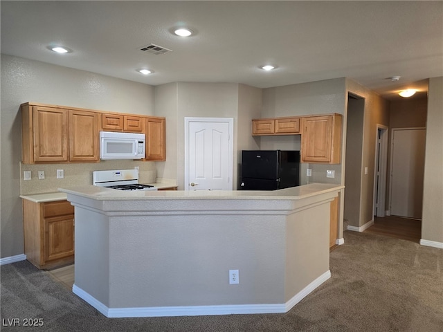 kitchen featuring light countertops, white appliances, visible vents, and light colored carpet