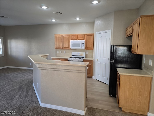 kitchen with light countertops, white appliances, an island with sink, and visible vents