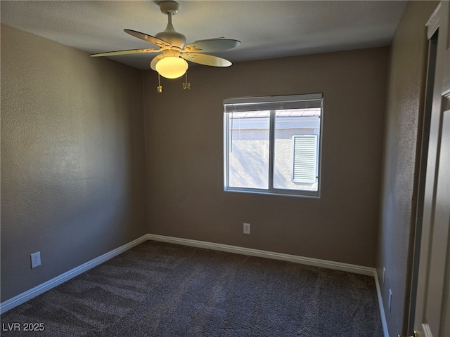 carpeted empty room featuring a ceiling fan and baseboards