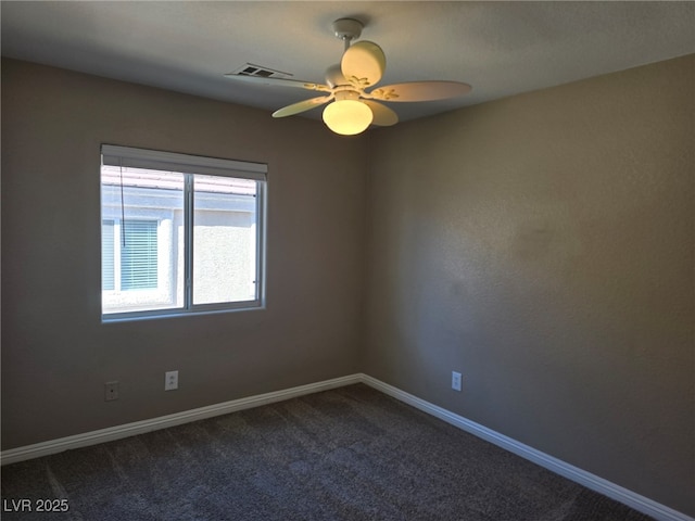 carpeted empty room featuring baseboards, visible vents, and a ceiling fan