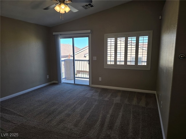 empty room featuring lofted ceiling, dark colored carpet, visible vents, and baseboards