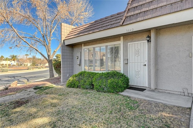 doorway to property with a yard