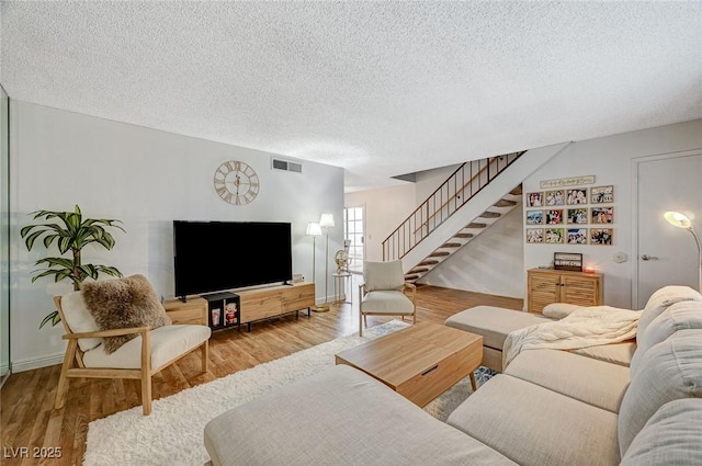 living room with a textured ceiling and hardwood / wood-style floors