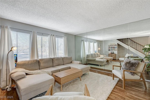 living room with wood-type flooring, a textured ceiling, and a wealth of natural light