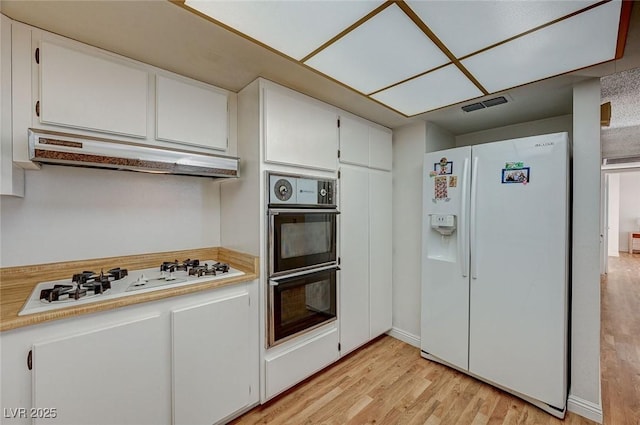 kitchen with white cabinets, white appliances, and light hardwood / wood-style flooring