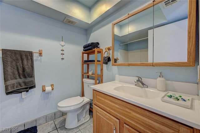 bathroom with toilet, tile patterned flooring, walk in shower, and vanity