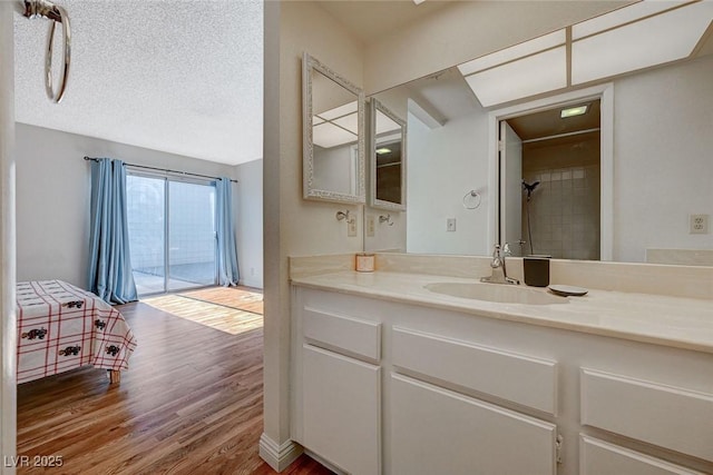 bathroom featuring wood-type flooring, vanity, and a textured ceiling