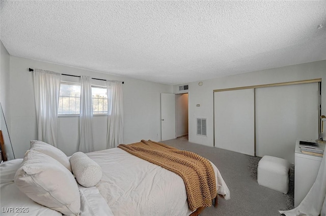 bedroom featuring carpet floors, a textured ceiling, a closet, and washer / clothes dryer