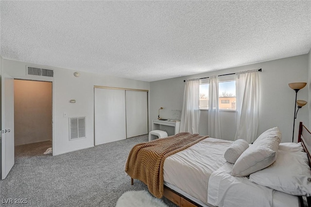 bedroom featuring a closet, a textured ceiling, and carpet flooring