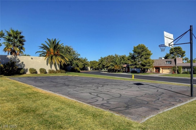 view of basketball court with a yard