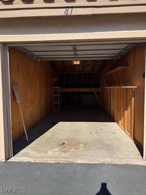 garage with a garage door opener and wood walls