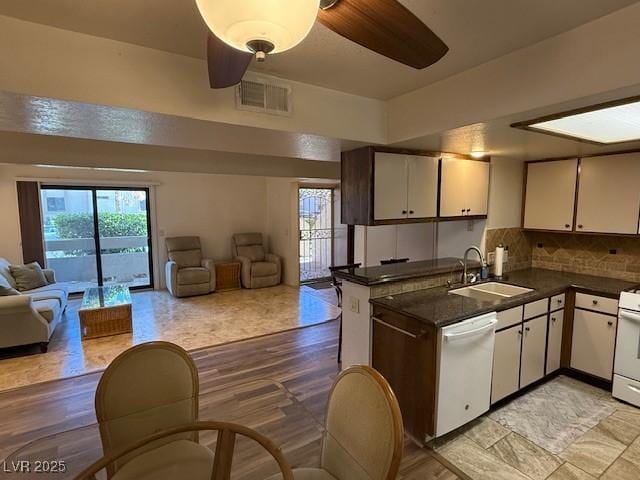 kitchen featuring sink, white appliances, white cabinets, and kitchen peninsula