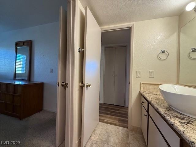 bathroom with a textured ceiling and vanity