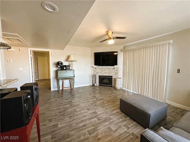 living room with ceiling fan, wood-type flooring, and a fireplace