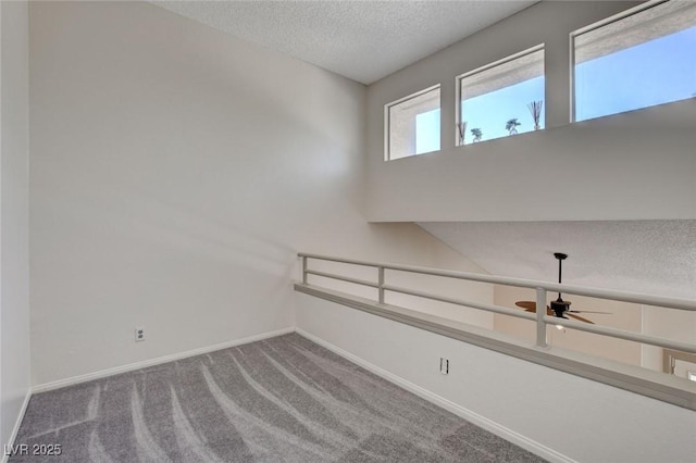 spare room with a textured ceiling, ceiling fan, and carpet floors