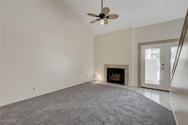 unfurnished living room featuring light carpet, ceiling fan, a tile fireplace, and high vaulted ceiling