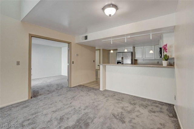 kitchen featuring stainless steel fridge with ice dispenser, light carpet, kitchen peninsula, decorative light fixtures, and white cabinets