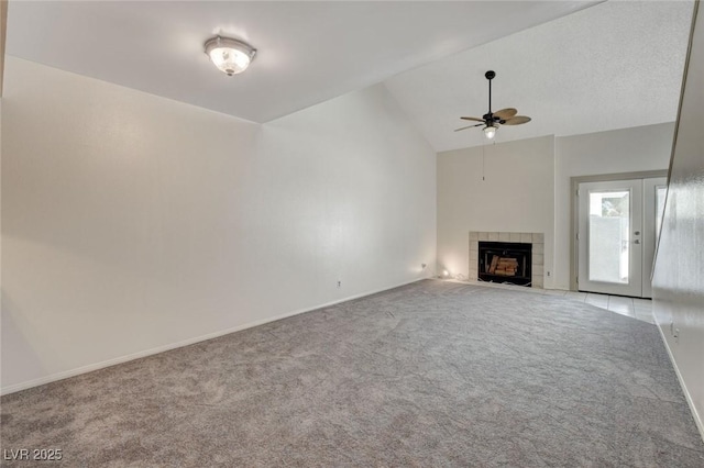 unfurnished living room with lofted ceiling, light colored carpet, ceiling fan, and a fireplace