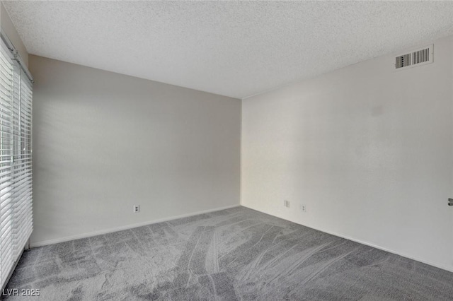 carpeted spare room featuring a textured ceiling